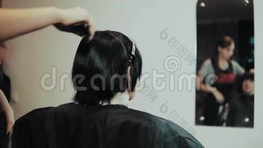 发型师在<strong>美发</strong>沙龙理发时剪女发。
